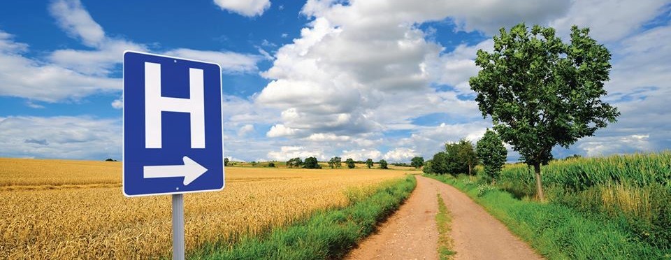 rural area with a sign indicating the nearest healthcare facility is far away